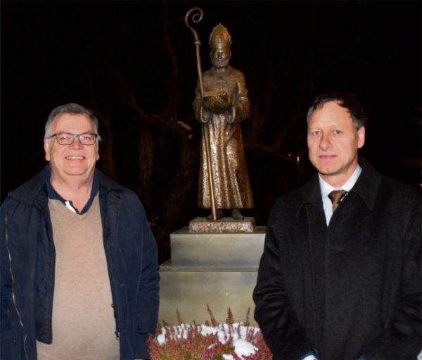 Paul Neumair (links) und Michael Burger vor der neuen Nikolaus-Skulptur amDorfbrunnen in Issing.